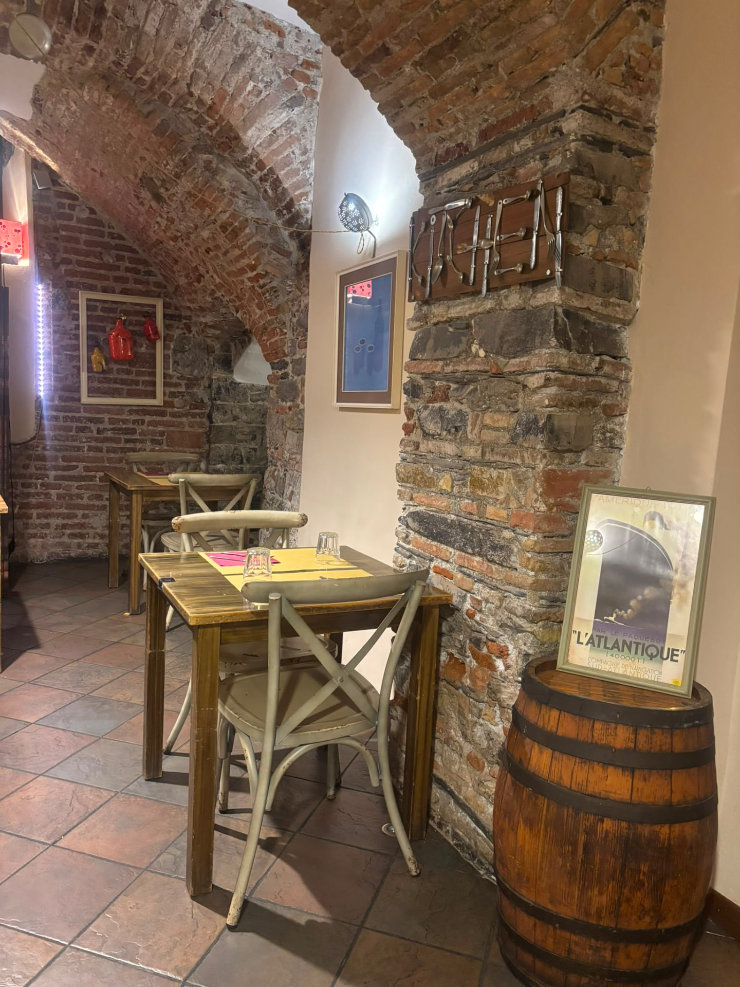 Sala interna di Soul Kitchen con volte in mattoni, tavoli in legno e stampe vintage