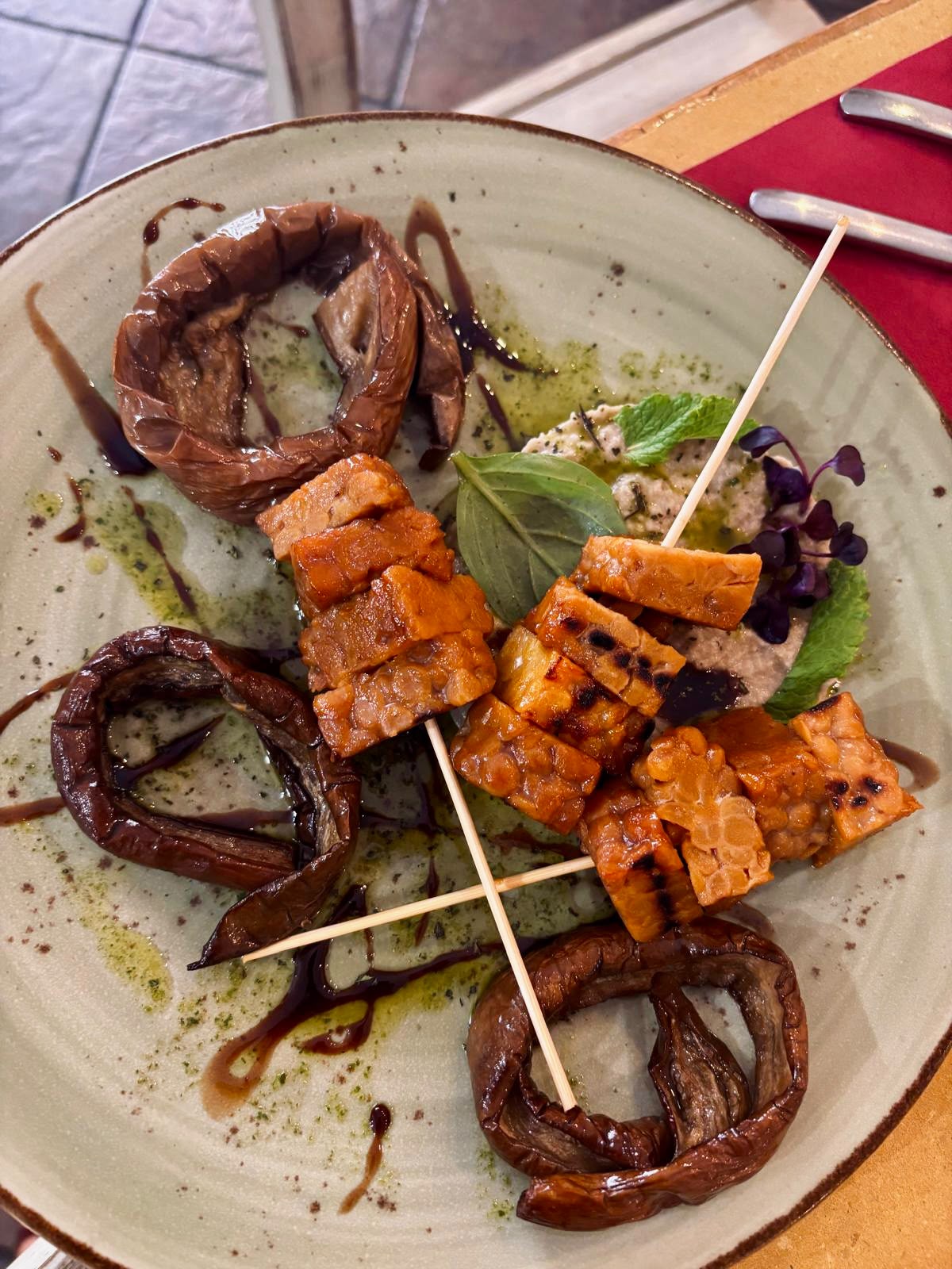 Tempeh di ceci grigliato e affumicato con babaganoush, melanzana perlina stufata e melassa di melograno