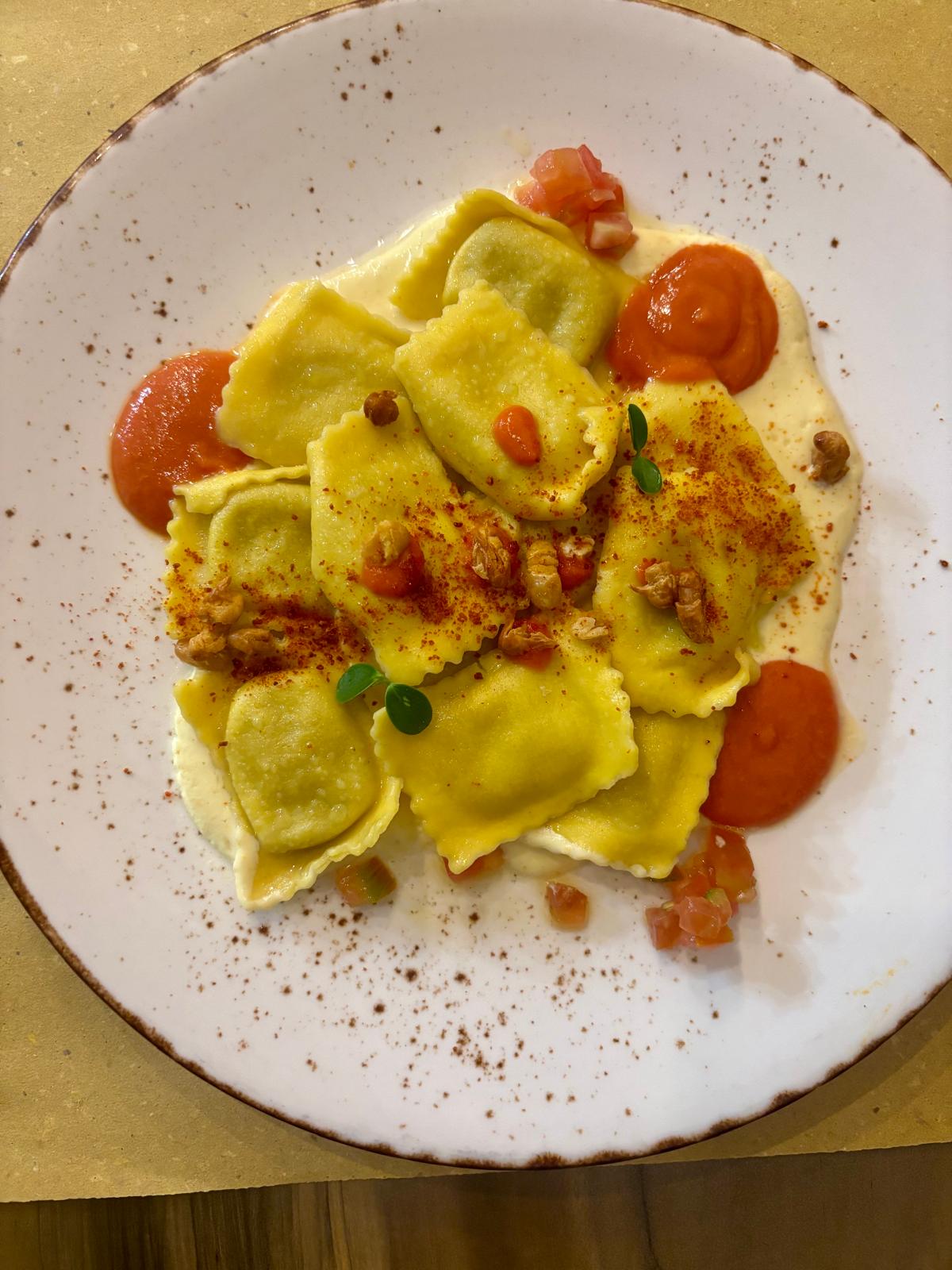 Il raviolo di cannellini ed erbette mediterranee con coulis di datterini gialli e rossi
